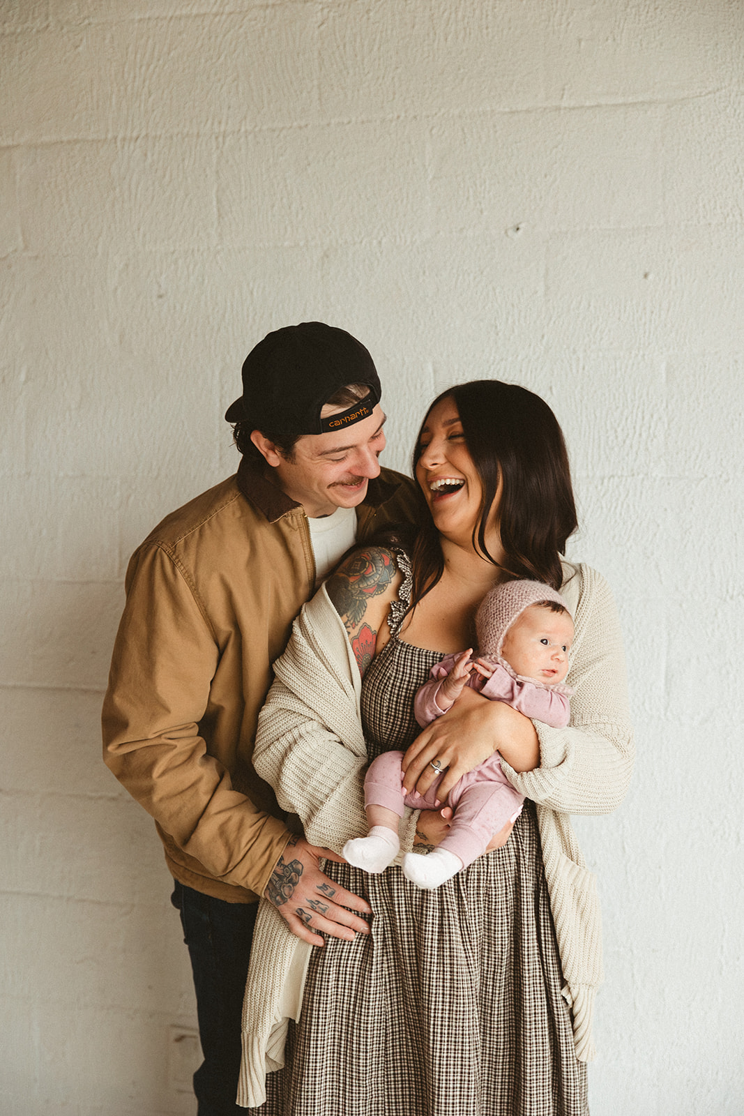 A mom and dad holding a baby during studio family photos