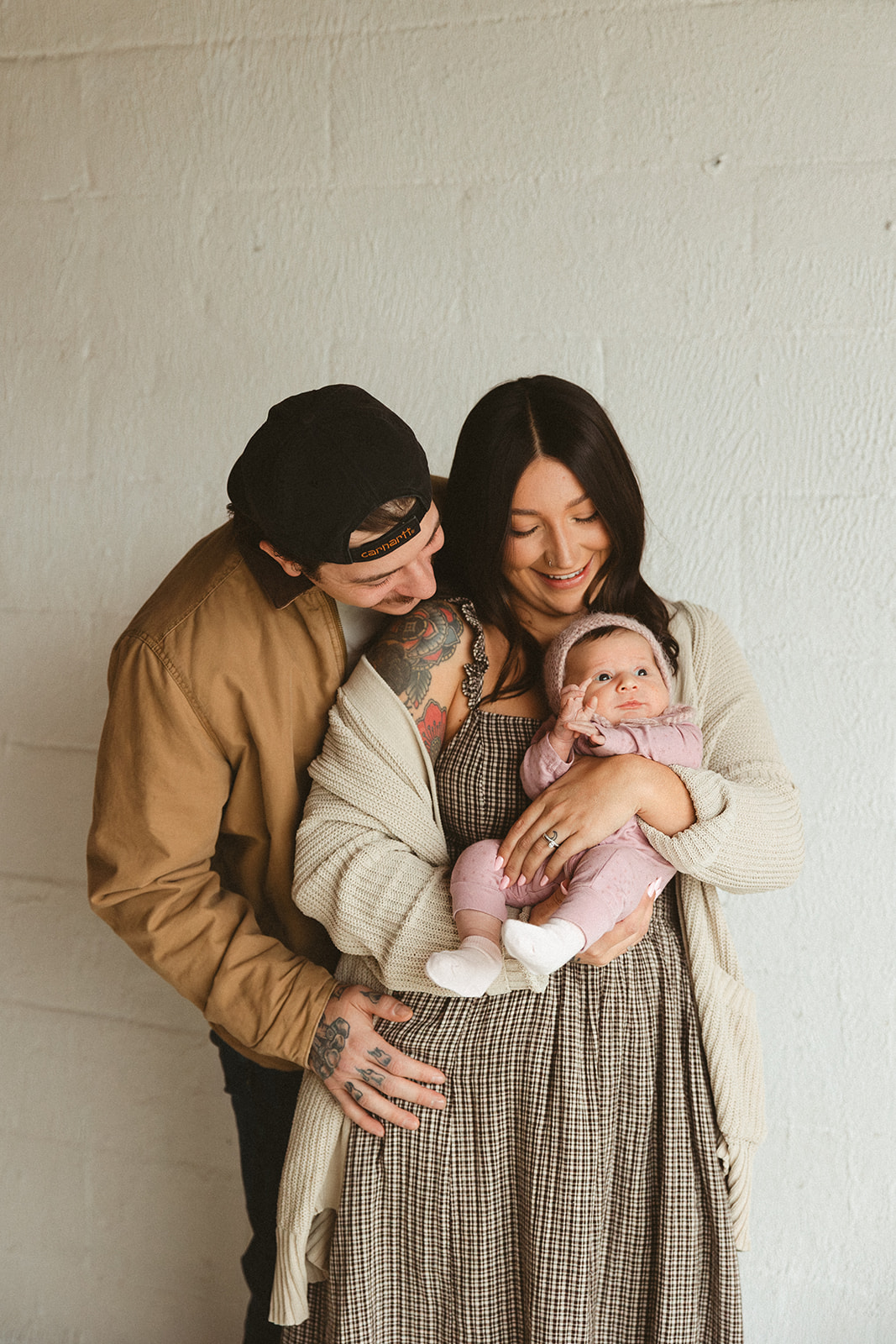 A mom and dad holding a baby during studio family photos