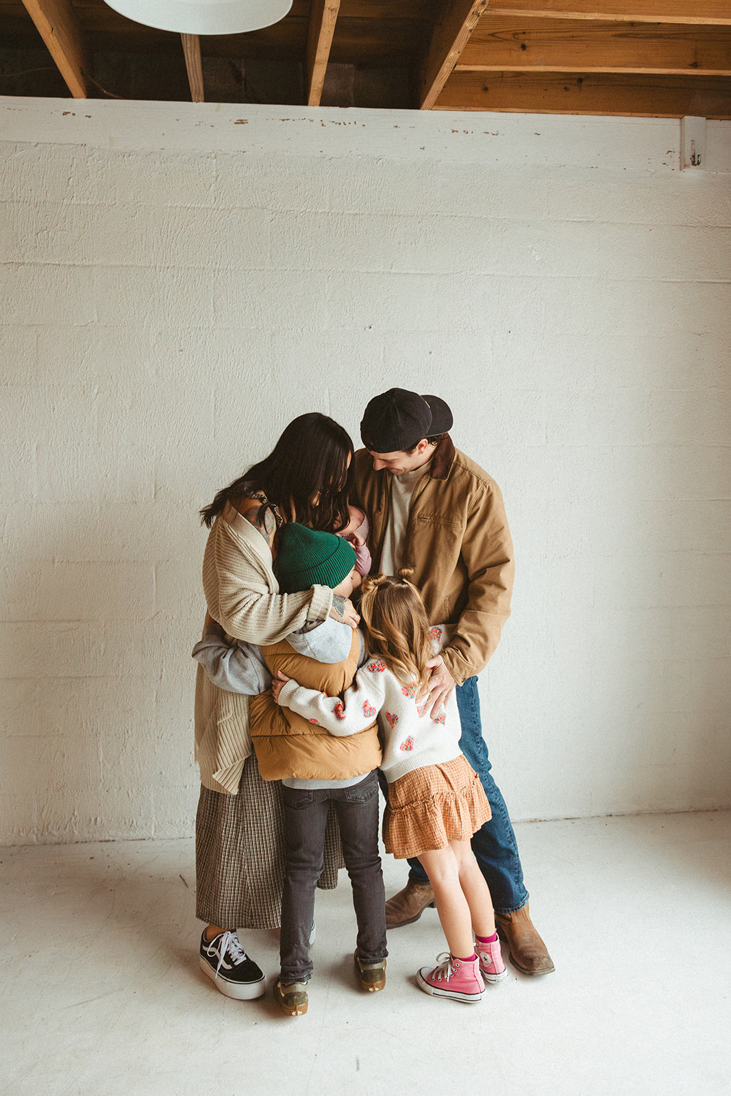 A family posing for studio family photos in front of a white wall