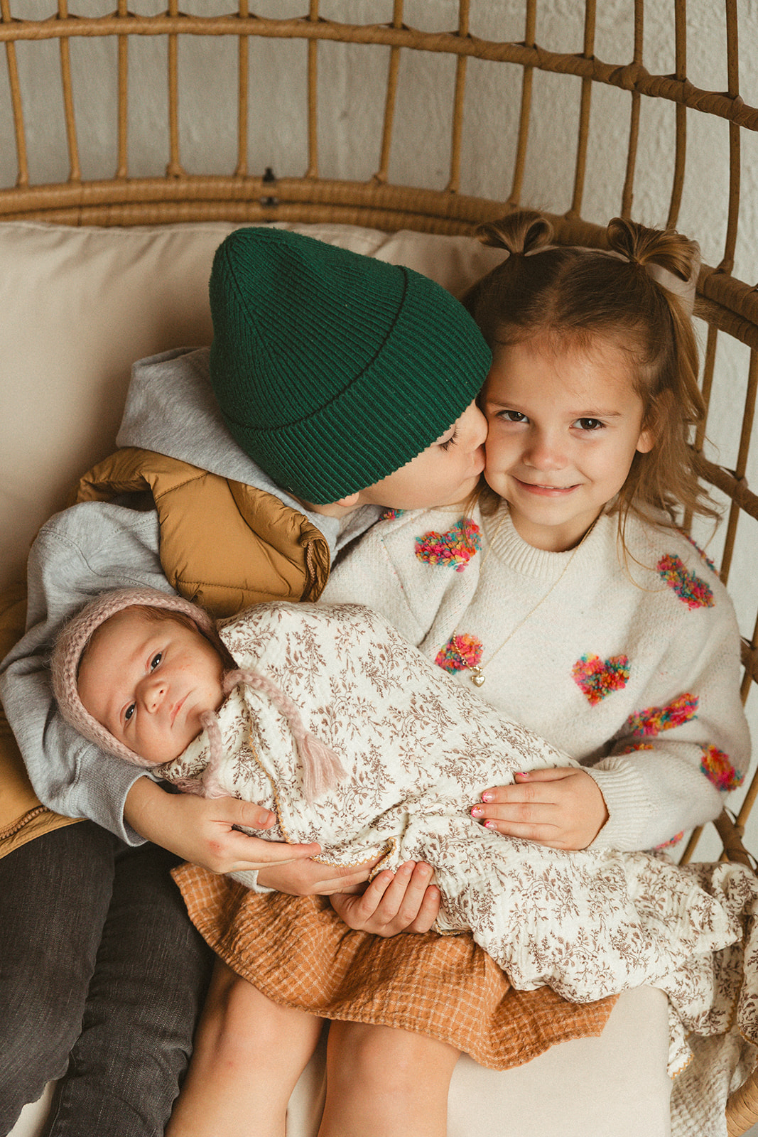 Two kids holding their baby sibling