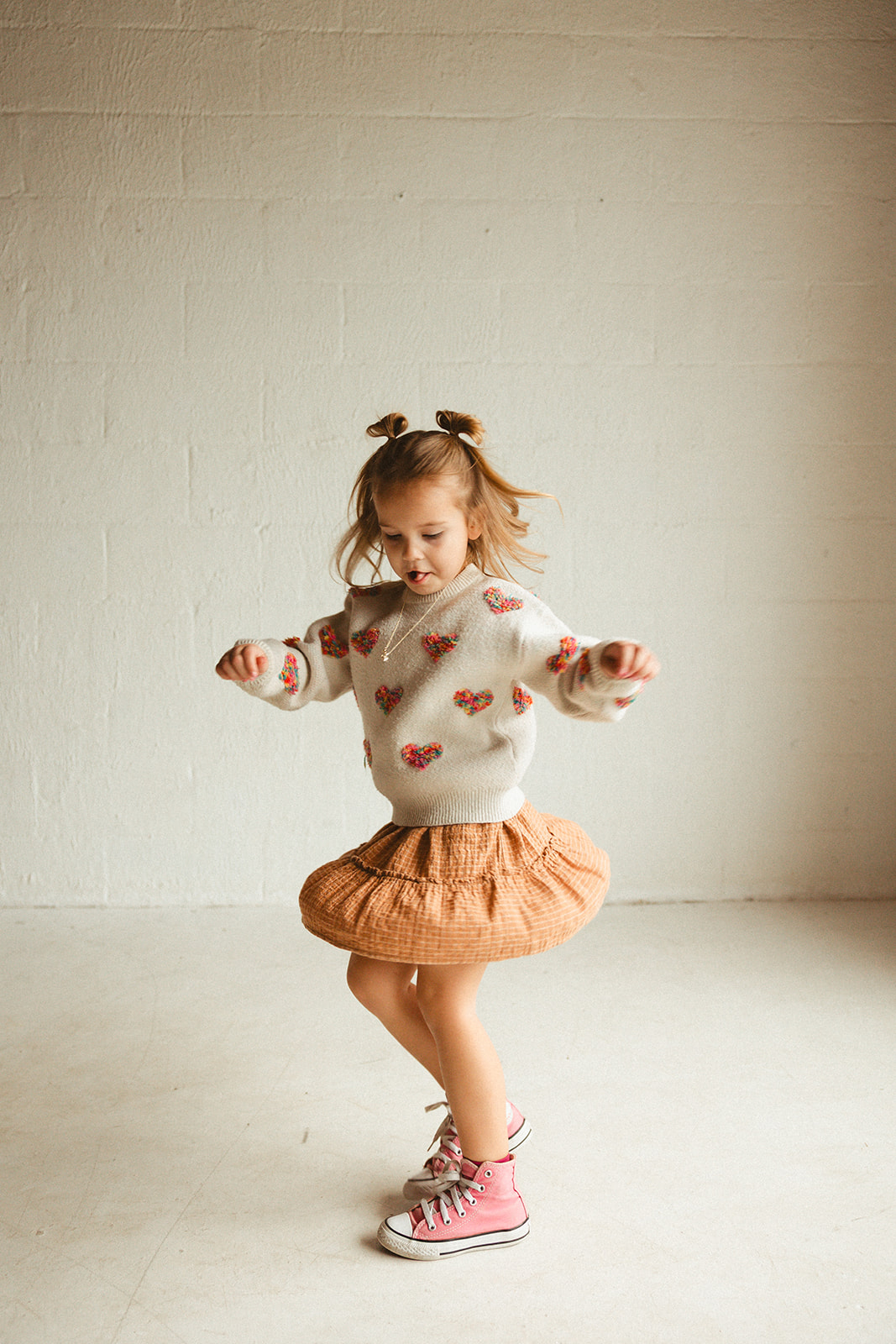 A little girl spinning during studio family photos
