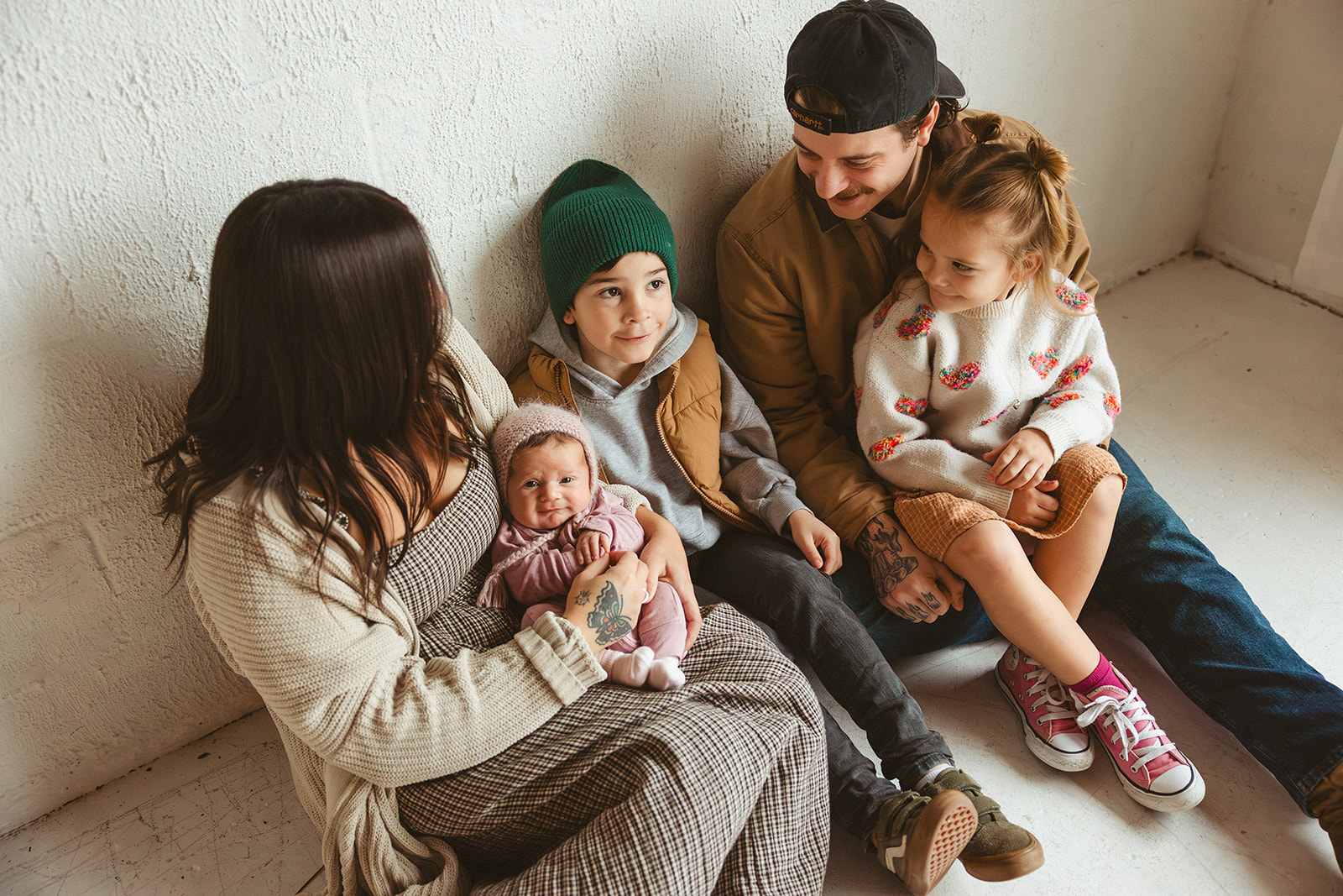 A family on the floor posing for studio family photos