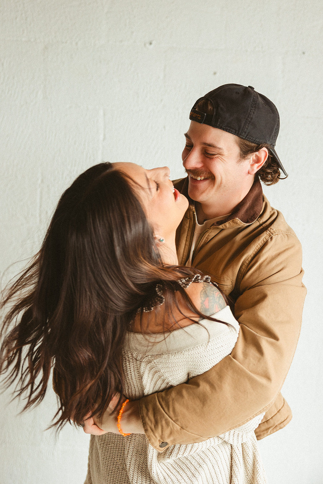 Two parents posing for photos in a studio