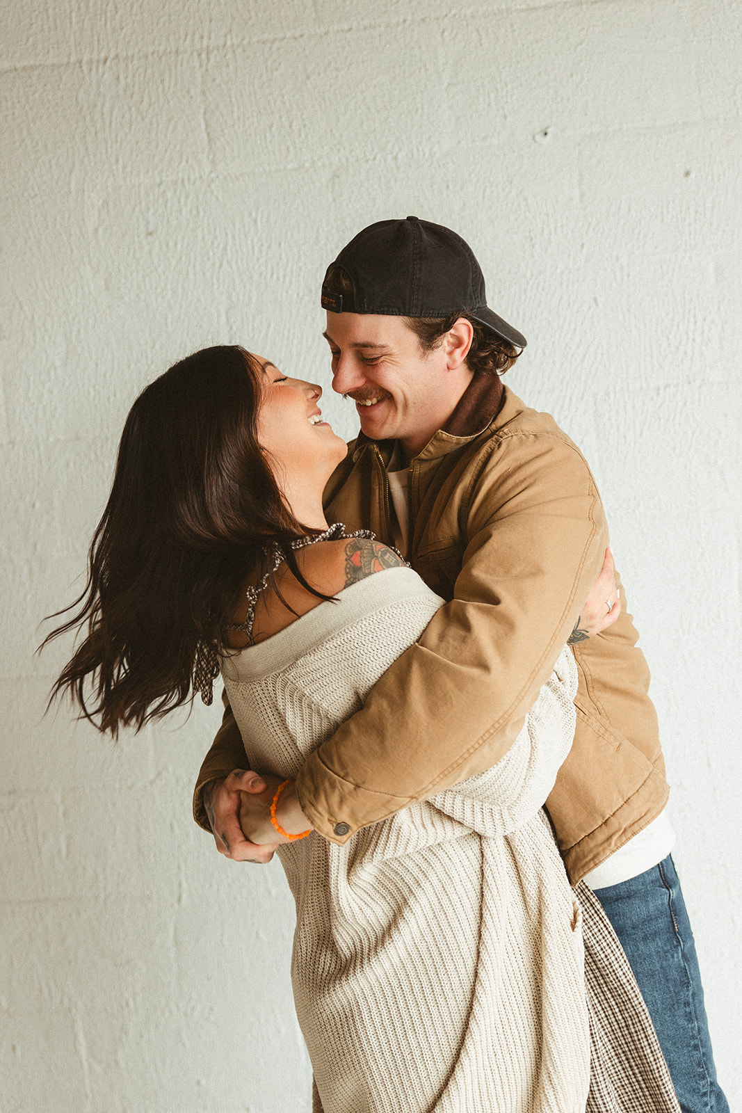 Two parents posing for photos in a studio