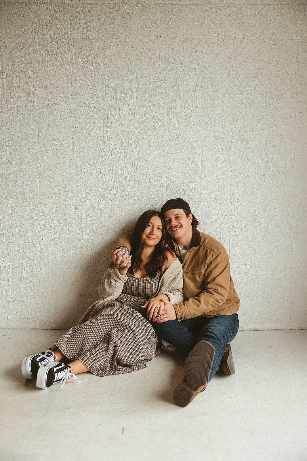 A mom and dad posing for family photos in a studio
