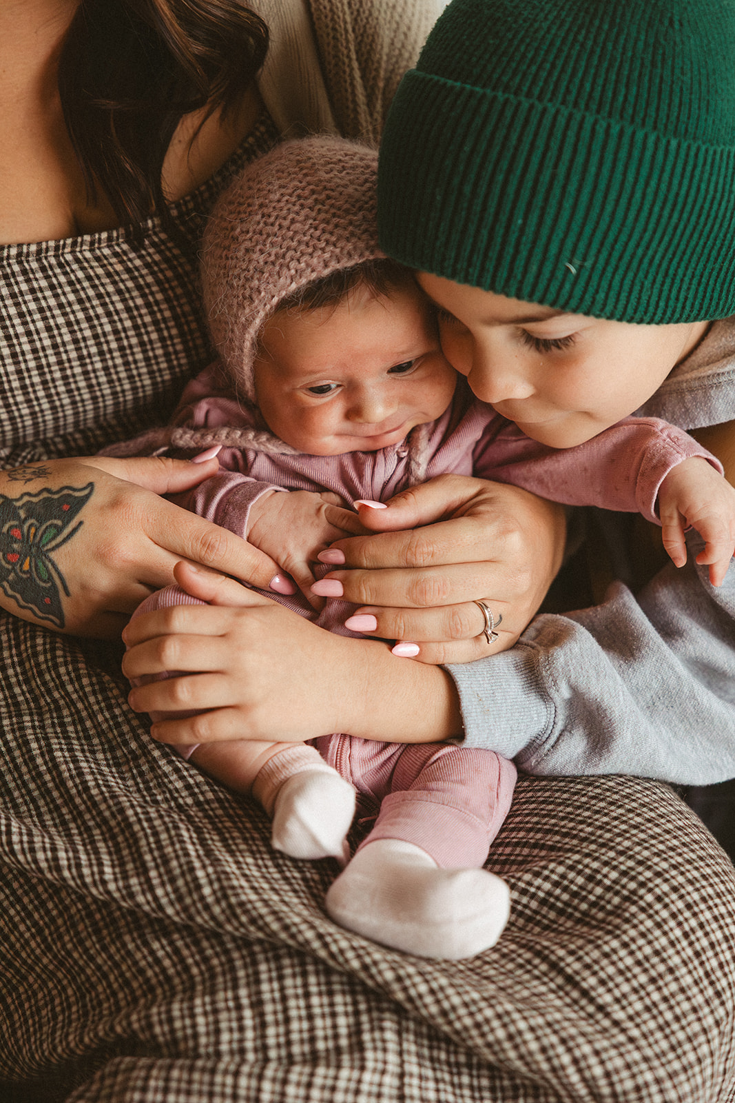 A little boy snuggling against his baby sister during family photos