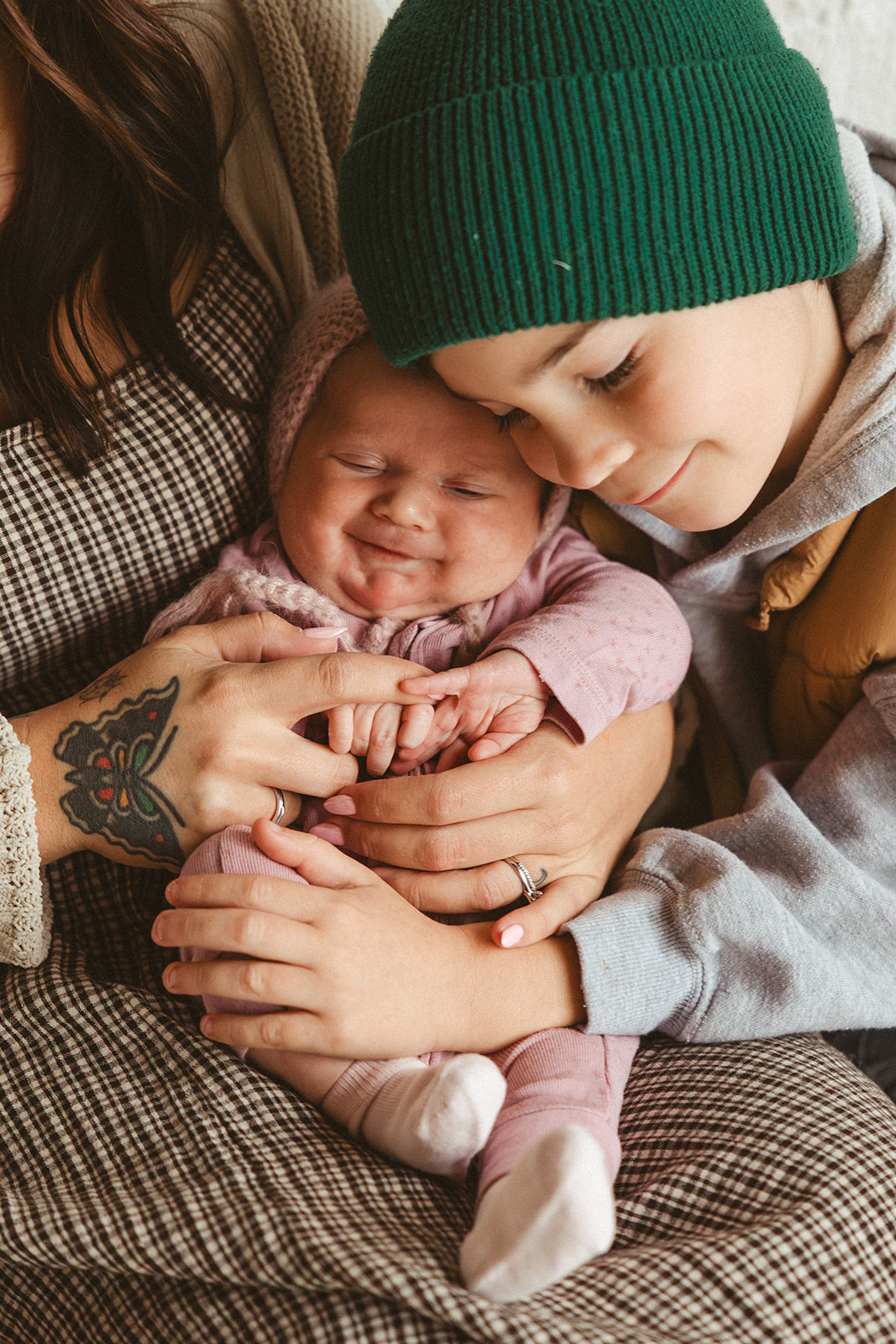 A little boy snuggling against his baby sister during family photos