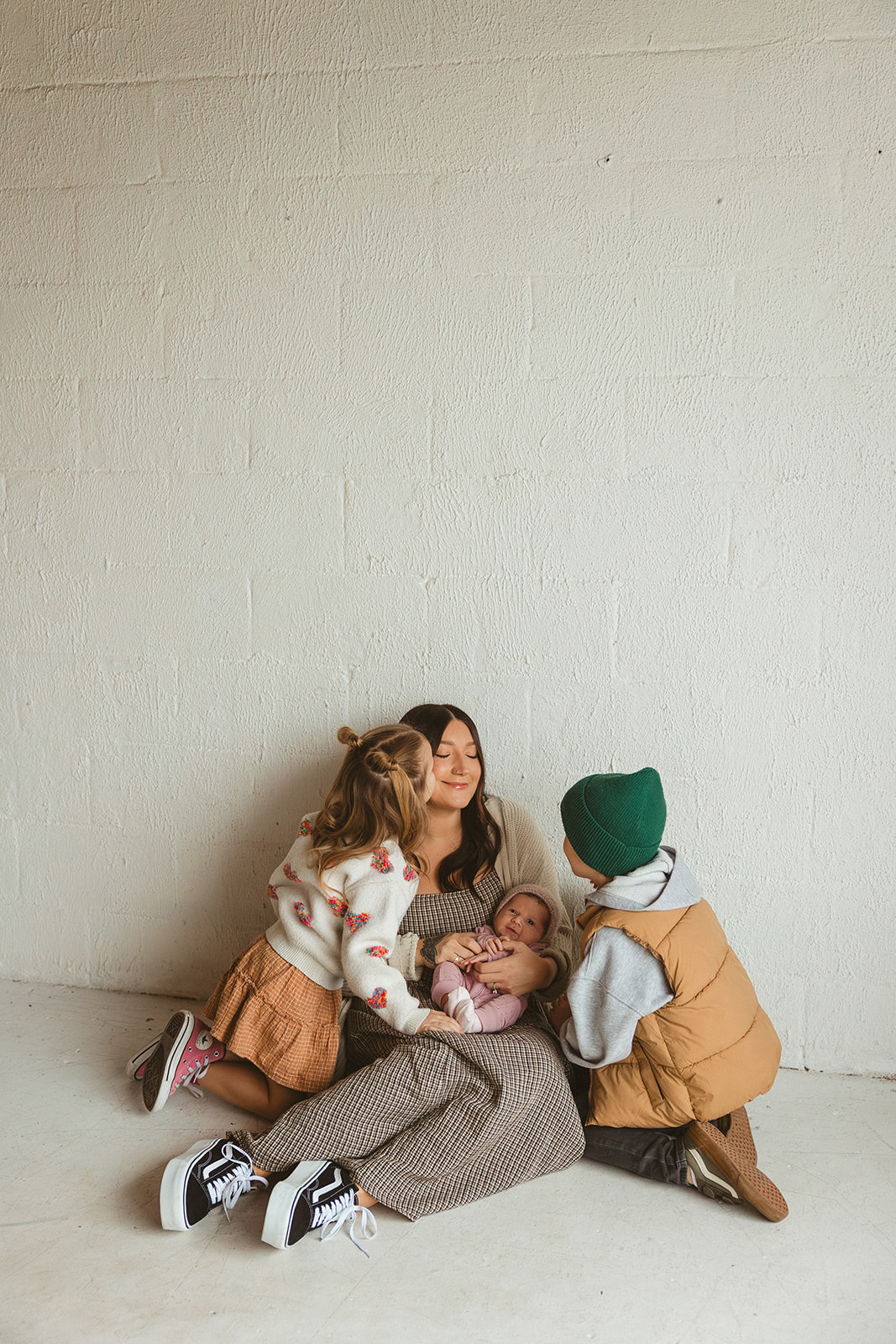 A girl kissing her mom on the cheek during family photos